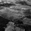 Oblique aerial view centred on the remains of the unenclosed settlement, field system and rig, looking to the NNW.