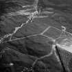 Oblique aerial view centred on the remains of a settlement, ring ditches and field system at Burn of Mannie, looking to to the SW.