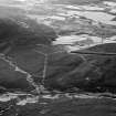 Oblique aerial view centred on the remains of a settlement, ring ditches and field system at Burn of Mannie, looking to to the NW.