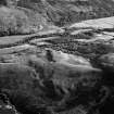 Oblique aerial view centred the remains of a field system and hut circles at Burn of Holmhead, lloking to the NE.