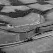 Oblique aerial view centred on cropmarks of the unenclosed settlement, roundhouses and rig at Logie House, looking to the NE.