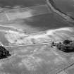 Oblique aerial view centred on the cropmarks of an enclosure, ring ditches, field system and pits at Wester Fintray, looking to the SSW. 

