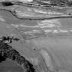Oblique aerial view centred on the cropmarks of the enclosure, rig, pits and possible rectangular buildings at Legatesden, looking to the SW.

