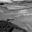 Oblique aerial view centred on the cropmarks of the enclosure, rig, pits and possible rectangular buildings at at Legatesden, looking to the SW.


