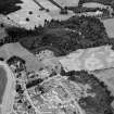 Oblique aerial view centred on the cropmarks of the palisaded enclosure, linear features, pits and rig at Heogan and East Mains of Aboyne, looking to the NNE.

