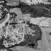 Oblique aerial view centred on the cropmarks of the palisaded enclosure, linear features, pits and rig at Heogan and East Mains of Aboyne, looking to the W.

