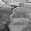 Oblique aerial view centred on the cropmarks of an unenclosed settlement, ring ditches, possible souterrain and pits at Newmill, looking to the SSW.