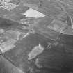 Oblique aerial view centred on the cropmarks of the unenclosed settlement, ring ditches, pits and rig at Bloodymire, looking to the NW.