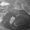 Oblique aerial view centred on the cropmarks of the unenclosed settlement, ring ditches, pits and rig at Bloodymire, looking to the NW.