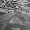 General oblique aerial view west of the cropmarks of the unenclosed settlement, ring ditches, pits and rig at Bloodymire, looking to the W.