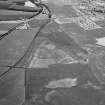 Oblique aerial view centred on the cropmarks of the unenclosed settlement, ring ditches, pits and rig at Bloodymire, looking to the W.