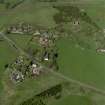 Oblique aerial view of the village centred on the burial-ground, manse and the remains of the church with the farmsteading adjacent, taken from the S.