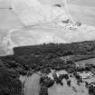 Oblique aerial view centred on Craigston Castle with the cropmarks of an unenclosed settlement, ring ditches, enclosures and pits adjacent, looking to the SW.