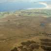 General oblique aerial view looking across the peat cutting and the remains of the chambered cairn towards the modern crofting township of Aird Thunga, taken from the NW.