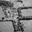 Oblique aerial view centred on the country house with the stables adjacent, taken from the NW.