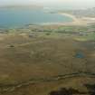 General oblique aerial view looking across the peat cutting and the remains of the chambered cairn towards the modern crofting township of Aird Thunga, taken from the NW.