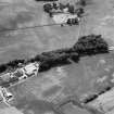 Oblique aerial view centred on the cropmarks of the fort, ring ditch and rig at Mains of Edzell with the farmstead adjacent, looking to the W.