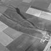 Oblique aerial view centred on the cropmarks of a rectlinear enclosure, possible souterrains, pits and rig at Chapel Knap, looking to the SE.