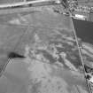 Oblique aerial view centred on cropmarks of the unenclosed settlement, roundhouses, pits and rig at Pittengardner, looking to the SE.