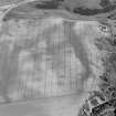 Oblique aerial view centred on the cropmarks of an enclosure, roundhouses, a possible four poster stone circle, possible souterrains, pits and rig at Pitcarry, looking to the ESE.