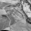 Oblique aerial view centred on the cropmarks of an enclosure, roundhouses, a possible four poster stone circle, possible souterrains, pits and rig at Pitcarry, looking to the SE.