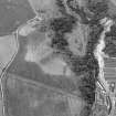 Oblique aerial view centred on the cropmarks of rig, a possible enclosure or long barrow at Rothes with Glenrothes Distillery adjacent, looking to the WNW.
