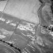 Oblique aerial view centred on the cropmarks of the enclosure, rig, pits and possible rectangular buildings, looking to the NNE.