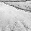 Oblique aerial view centred on the remains of a settlement, ring ditches and field system at Burn of Mannie, looking to the SSE.