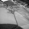 Oblique aerial view centred on the excavation of the earthwork and enclosure at Thomshill with Glenlossie distillery adjacent, looking to the E.