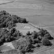 Oblique aerial view centred on the remains of the stone circle and enclosed cremation cemetery at Loanhead of Daviot, looking to the NW.