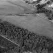 Oblique aerial view centred on the cropmarks of the unenclosed settlement, ring ditches, pits and possible souterrains at Nairn, looking to the N.
