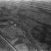 Oblique aerial view centred on the cropmarks of the unenclosed settlement, ring ditches, souterrains and rig at Westside, looking to the NW.