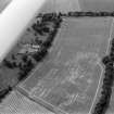 Oblique aerial view centred on the cropmarks of the palisaded settlement, roundhouse, possible barrows and linear features at Priestfield, with the walled garden at Anniston House adjacent,looking to the SW.