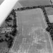 Oblique aerial view centred on the cropmarks of the palisaded settlement, roundhouse, possible barrows and linear features at Priestfield, with the walled garden at Anniston House adjacent,looking to the SW.
