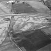Oblique aerial view centred on the cropmarks of the pit defined cursus and linear features at Purlieknowe, looking to the ENE.