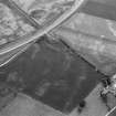 Oblique aerial view centred on the cropmarks of the rig with the farmstead of Bellfield adjacent, looking to the N.