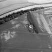 Oblique aerial view centred on the cropmarks of the palisaded enclosure, square and round barrows at Fisherhills, looking to the NNE.