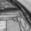 Oblique aerial view centred on the cropmarks of the palisaded enclosure, square and round barrows at Fisherhills, looking to the WNW.