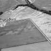 Oblique aerial view centred on the cropmarks of the pit defined cursus, unenclosed settlement, ring ditches, pits and rig with Stracathro Roman Temporary Camp adjacent at Inchbare North, looking to the NW.
