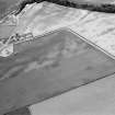 Oblique aerial view centred on the cropmarks of the pit defined cursus, unenclosed settlement, ring ditches, pits and rig with Stracathro Roman Temporary Camp adjacent at Inchbare North, looking to the N.