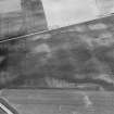 Oblique aerial view centred on the cropmarks of the roundhouses and ring ditches of the unenclosed settlement with the farmstead adjacent at Newbigging, looking to the NW.