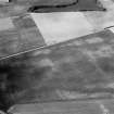 Oblique aerial view centred on the cropmarks of the roundhouses and ring ditches of the unenclosed settlement with the farmstead adjacent at Newbigging, looking to the NNW.