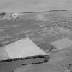 Oblique aerial view centred on the cropmarks of the unenclosed settlement, ring ditches, rectilinear enclosure and pits at Newbigging, looking to the S.