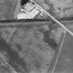 Oblique aerial view centred on the cropmarks of the Roman Temporary Camp, linear features, enclosure, pits and rig at Gilrivie with the farmstead adjacent, looking to the NW.