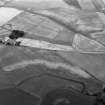 Oblique aerial view centred on the cropmarks of the enclosures, souterrains, barrows, ring ditches, linear features and pits at Newbarns, looking to the NE.