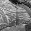 Oblique aerial view centred on the cropmarks of the enclosure, timber hall, unenclosed settlement and pits at Boysack, looking to the SSW.