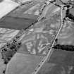 Oblique aerial view centred on the cropmarks of the unenclosed settlement, enclosure, ring ditches, pits and rig at Damside and Pitmuies, looking to the ESE.