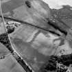 Oblique aerial view centred on the cropmarks of the enclosure,  linear features, Roman temporary camp, pits and rig with the farm adjacent at Gilrivie and Dun, looking to the ESE.