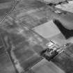 Oblique aerial view centred on the cropmarks of the roundhouses and ring ditches of the unenclosed settlement with the farmstead adjacent at Newbigging, looking to the WNW.