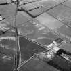 Oblique aerial view centred on the cropmarks of the unenclosed settlement, ring ditches, pits and rig with the farmhouse adjacent at Balwyllo, looking to the NNW.